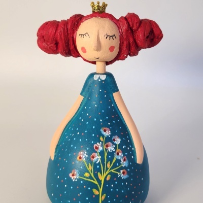 Figura decorativa de menina com cabelo vermelho e vestido azul florido