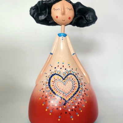 Estatueta de princesa colorida com coroa dourada e cabelo preto.