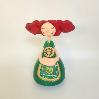 Figura de madeira com cabelo ruivo e vestido verde decorativo.