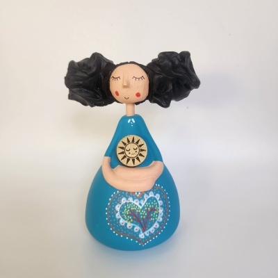 Boneca de cerâmica com vestido azul e cabelo preto enrolado