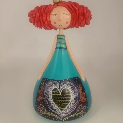 Estatueta de fada ou princesa colorida em cerâmica com vestido azul e coroa dourada.