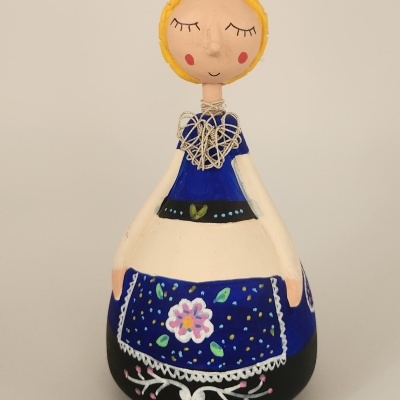 Boneca decorativa de cerâmica com vestido azul e avental floral