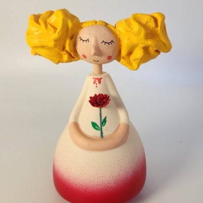 Figura decorativa de menina com vestido branco e vermelho e cabelo amarelo