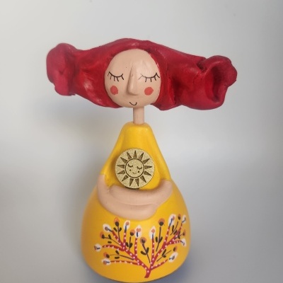 Estatueta decorativa de mulher com vestido amarelo e cabelo vermelho