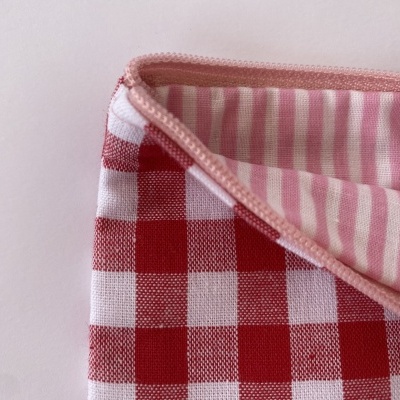 Pano de tecido aos quadrados vermelhos e brancos com interior às riscas rosas e brancas