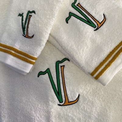 Conjunto de toalhas de banho brancas com bordado colorido e faixas amarelas