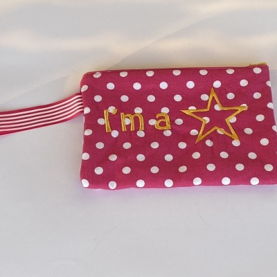 carteira rosa de tecido com bolinhas brancas e bordado 'I'm a' e estrela amarela