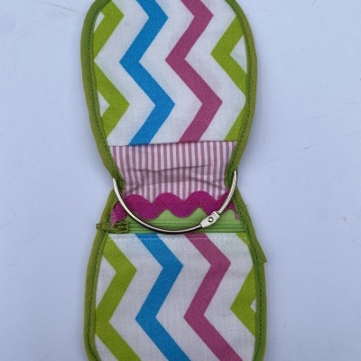Estojo aberto com padrão geométrico em zig zag colorido e fecho metálico