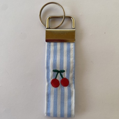Porta-chaves tecido azul claro e branco com bordado de cerejas e metal prateado