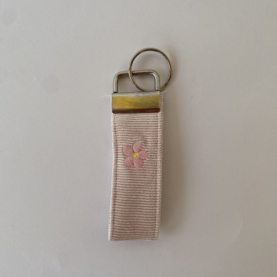 Porta-chaves tecido rosa claro com flor bordada e ferragens metálicas douradas