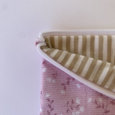 tecido rosa com flores brancas e interior de riscas bege e branco