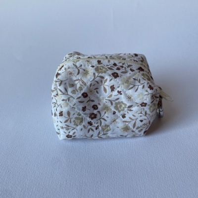 Estojo pequeno branco acolchoado com padrão floral castanho