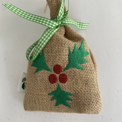 Saco pequeno de juta com laço verde e branco e bordado de folhas verdes e frutos vermelhos