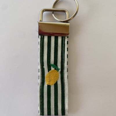 Porta-chaves com riscas verdes e brancas e bordado de limão amarelo.