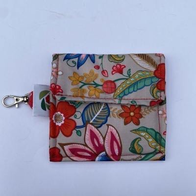 Carteira pequena em tecido floral com fecho e mosquetão.