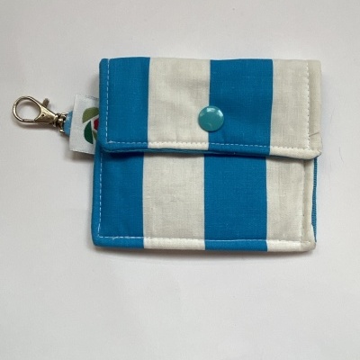 Carteira pequena azul e branca com botão e mosquetão