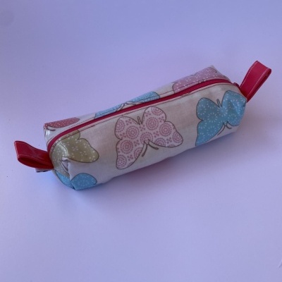 Estojo retangular com padrão de borboletas em tons pastel e fecho vermelho