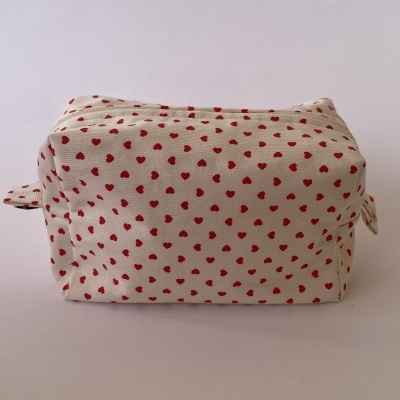 Estojo de tecido bege com padrão de corações vermelhos