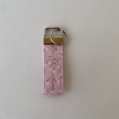 Porta-chaves rosa com padrão floral e metais prateados