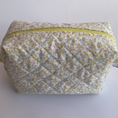 Estojo acolchoado com padrão floral amarelo e verde