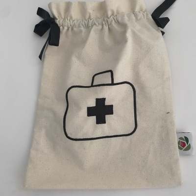 Saco de tecido cru com desenho preto de mala médica e cordões pretos para fechar