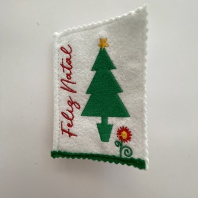 tecido branco com árvore de Natal verde e texto Feliz Natal bordado