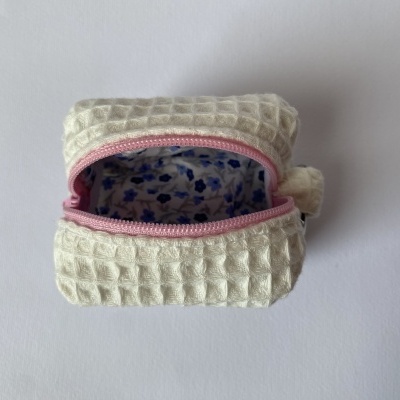 Bolsa pequena creme com fecho rosa e interior floral azul