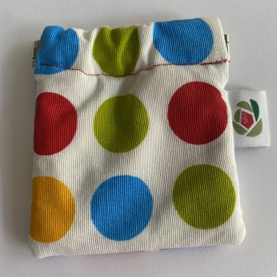 Saco de tecido com padrão de bolas coloridas e fecho metálico