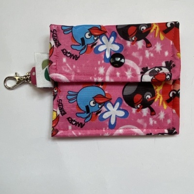 Carteira em tecido com padrão de pássaros sobre fundo cor-de-rosa