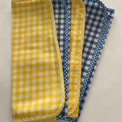 Quatro panos de cozinha xadrez amarelos e azuis sobre fundo branco