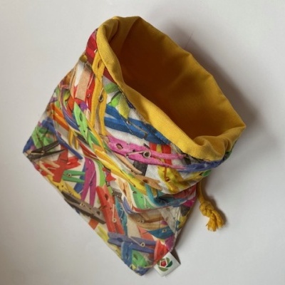 Saco de tecido com padrão colorido de molas de roupa e interior amarelo