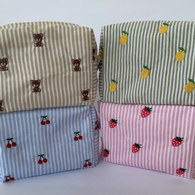 Quatro bolsas de tecido às riscas com bordados de ursinhos, limões, cerejas e morangos.