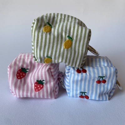 Três porta-moedas tecidos riscado com bordados de frutas