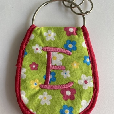 Chaveiro de tecido verde com flores coloridas e letra rosa E bordada