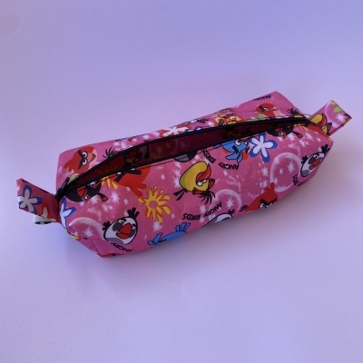 estojo escolar cor-de-rosa com padrão de personagens animados e fecho preto