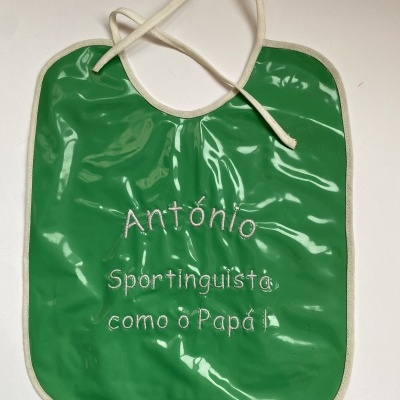 Babete verde com texto bordado branco e cordão para amarrar