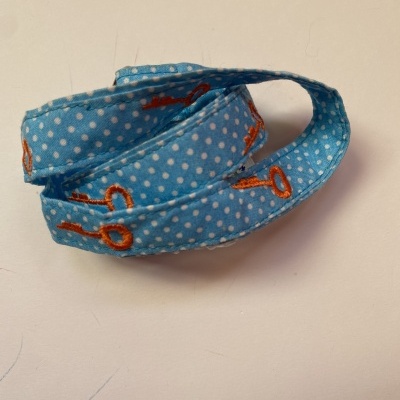 Fita azul com bolinhas brancas e chaves laranja enrolada