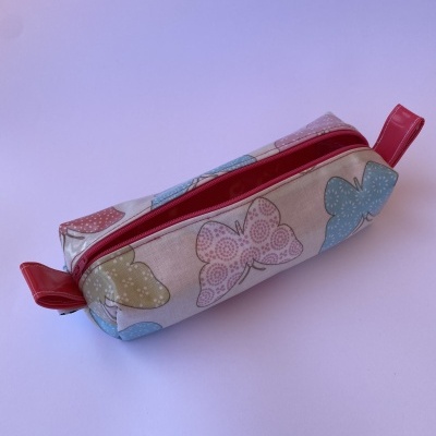 Estojo retangular com padrão de borboletas coloridas e fecho vermelho