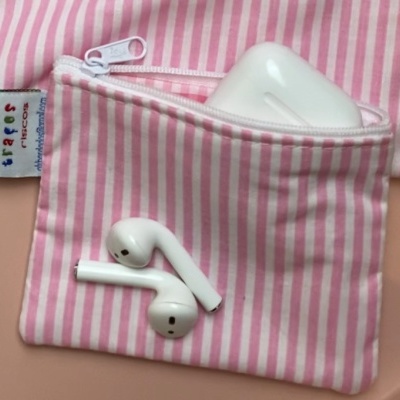 Bolsa riscada rosa e branca com fecho e auscultadores brancos em cima