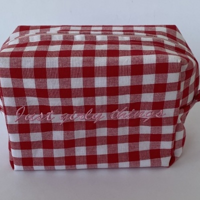 Bolsa de tecido xadrez vermelho e branco com texto bordado rosa