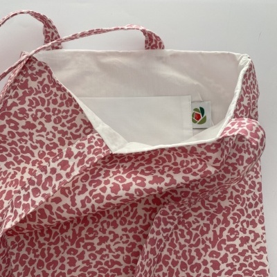 Saco de tecido rosa e branco com padrão de manchas e forro branco
