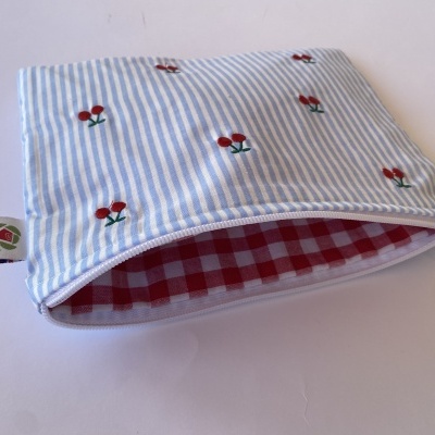 Estojo de tecido azul com riscas e pequenas cerejas bordadas