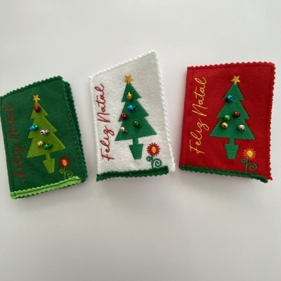 Capas de tecido para livros em feltro com decoração de árvore de Natal e texto 'Feliz Natal'