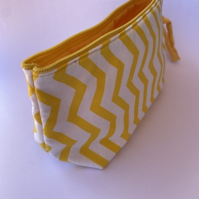 Bolsa de tecido com padrão amarelo e branco e fecho amarelo