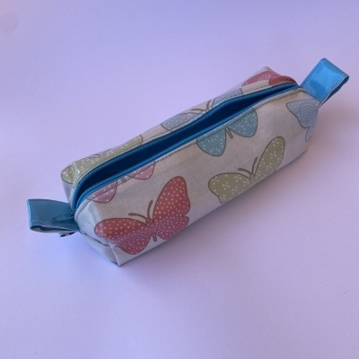 Estojo retangular com padrão de borboletas e fecho azul