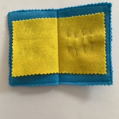 Alfineteiro portátil em feltro azul e amarelo com alfinetes
