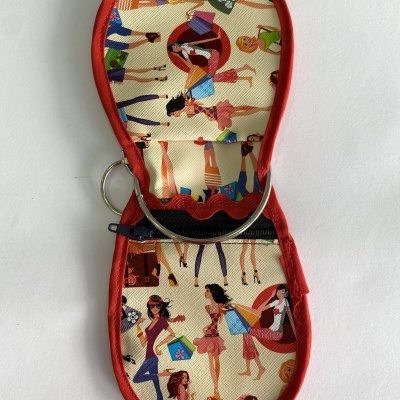 Estojo de tecido com padrão colorido de mulheres, borda vermelha, aberto