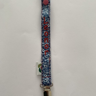 Clip de tecido azul floral com nome bordado Leonor e presilha metálica