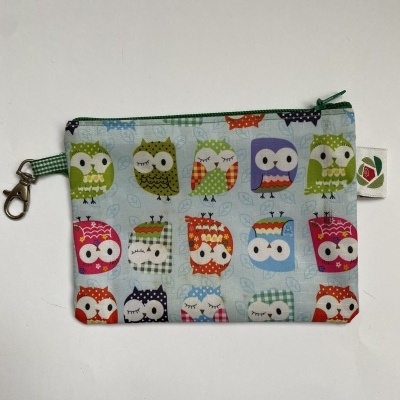 Mala pequena com padrão de corujas coloridas sobre fundo azul claro