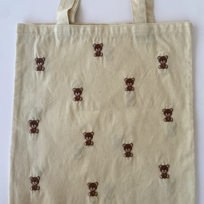 Saco de tecido bege com bordados de ursinhos castanhos